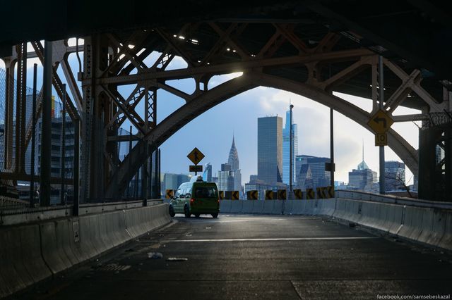 a green cab on a highway with Manhattan in the background